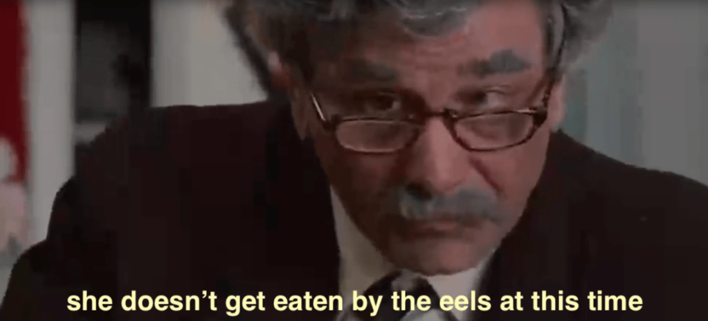Screenshot from the movie The Princess Bride where the narrator is subtitled saying "She doesn't get eaten by the eels at this time"